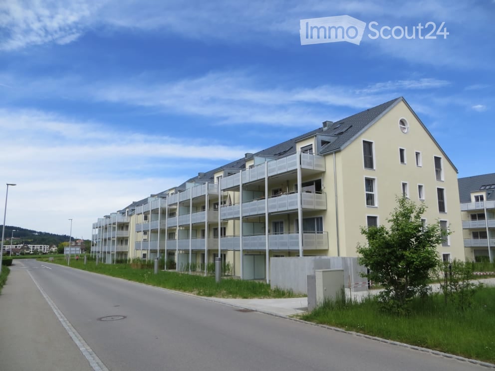 Modern multi-story apartment building with balconies and a clean, contemporary design.