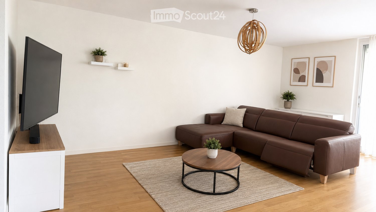 Modern living room with a brown leather sectional sofa, a round wooden coffee table, a flat-screen TV on a wooden stand, a hanging wooden lamp, and decorative shelves with plants and picture frames.