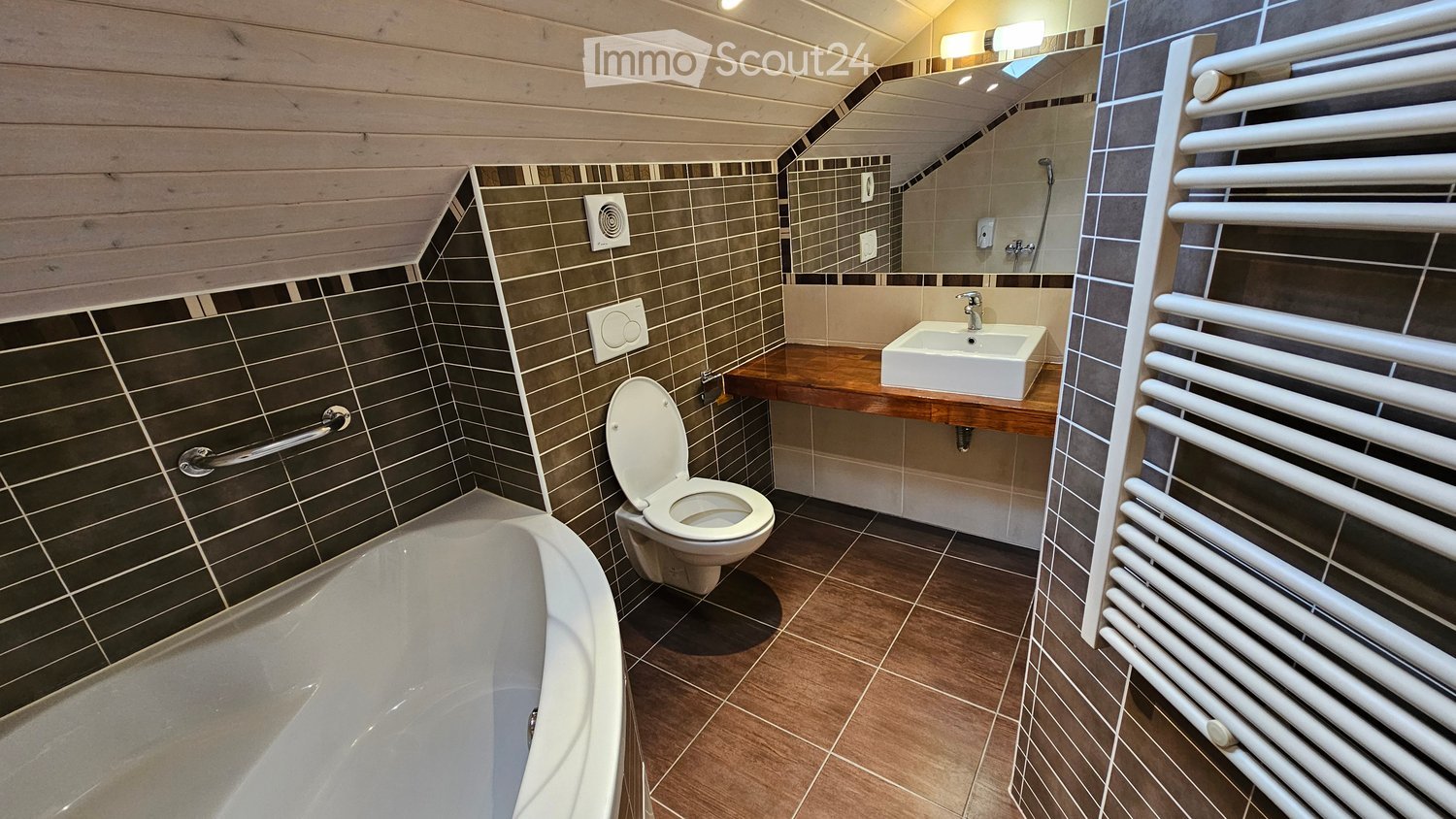 Bathroom with bathtub, toilet, sink, mirror, and towel radiator.