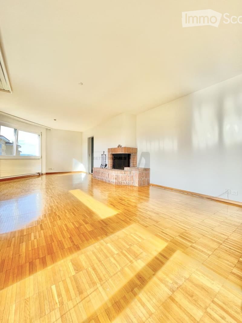 Empty room with wooden flooring, white walls, and a brick fireplace. No furniture or equipment present.