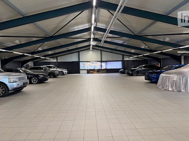 {"visible_features": ["Garage"], "type": "Garage", "objects": [], "description": "Large, well-lit garage with multiple parked cars, tiled floor, and high ceiling with exposed beams.", "localized_descriptions": {"EN": "Large, well-lit garage with multiple