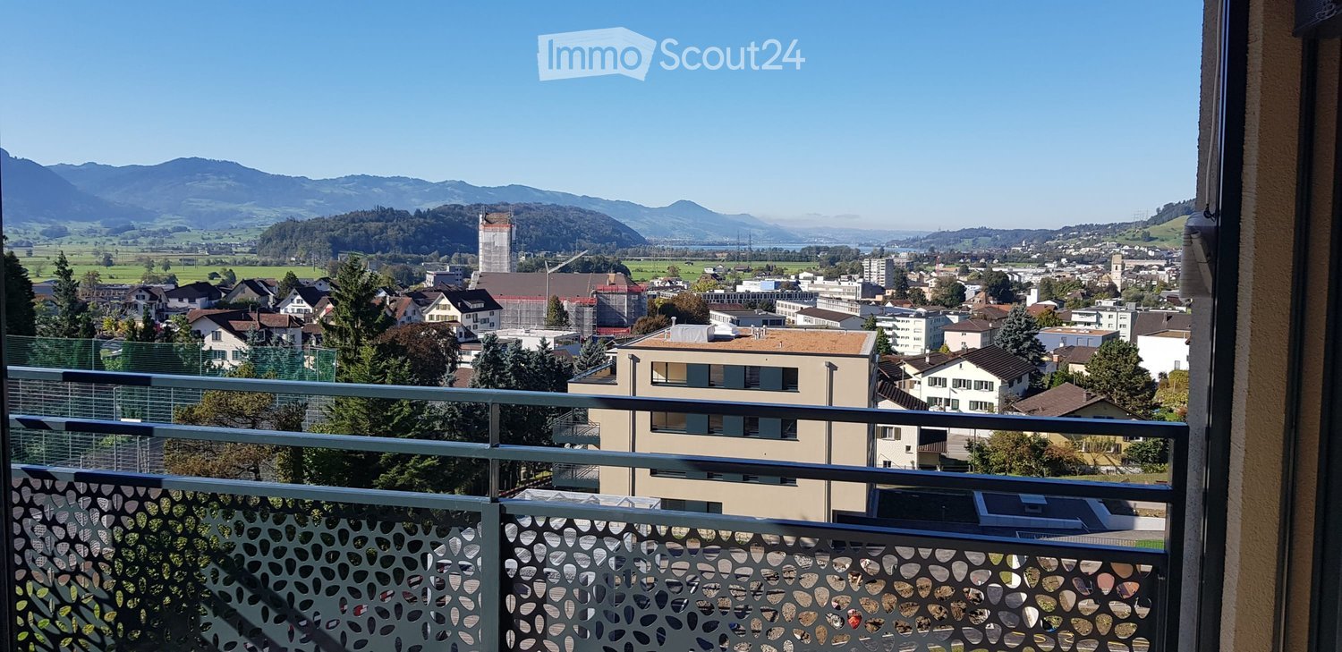 Balcony with metal railing, view of the town, mountains in the background