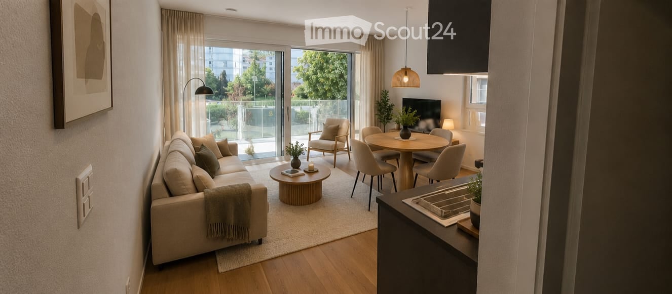 Modern, open-plan living and dining area with a sofa, coffee table, armchair, dining table, chairs, TV, and pendant lights. Large sliding glass doors lead to a balcony with outdoor seating.