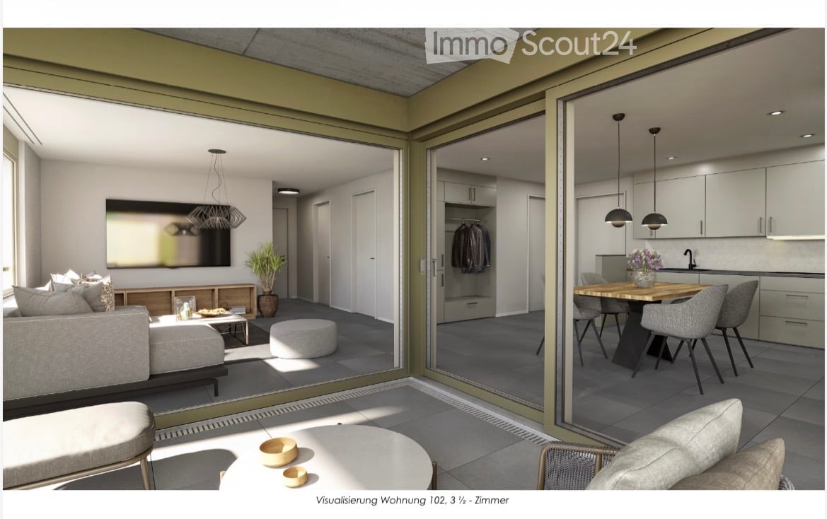 Modern, open-plan living and dining area with large glass doors leading to a balcony. Features a grey sofa, coffee table, ottoman, dining table with chairs, pendant lights, a mirror, and a small plant.