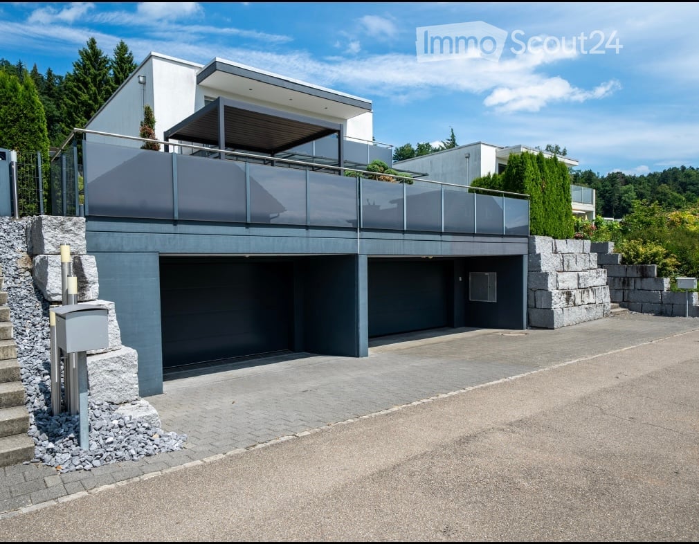 House with double garage, balcony with canopy, grey stone wall, modern architecture