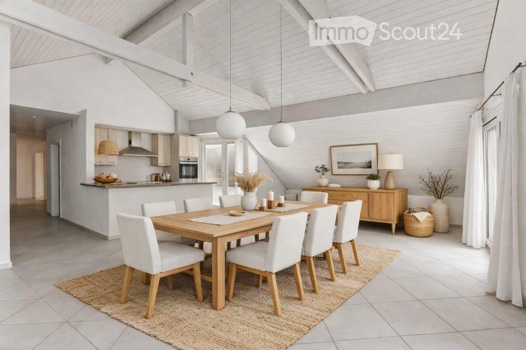 Bright, airy dining area with a wooden dining table and white chairs, pendant lights, a cabinet, and a small kitchen area in the background.