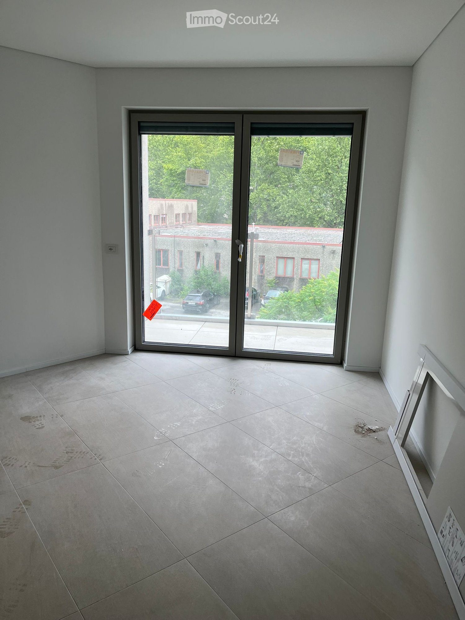 Empty room with tiled floor and large sliding glass door leading to an outdoor area. No furniture or equipment visible.