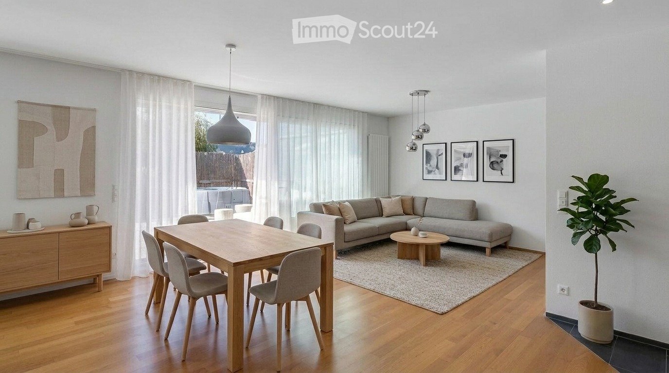 Modern living room with a grey sectional sofa, coffee table, dining table with chairs, pendant lights, and a large window with sheer curtains.