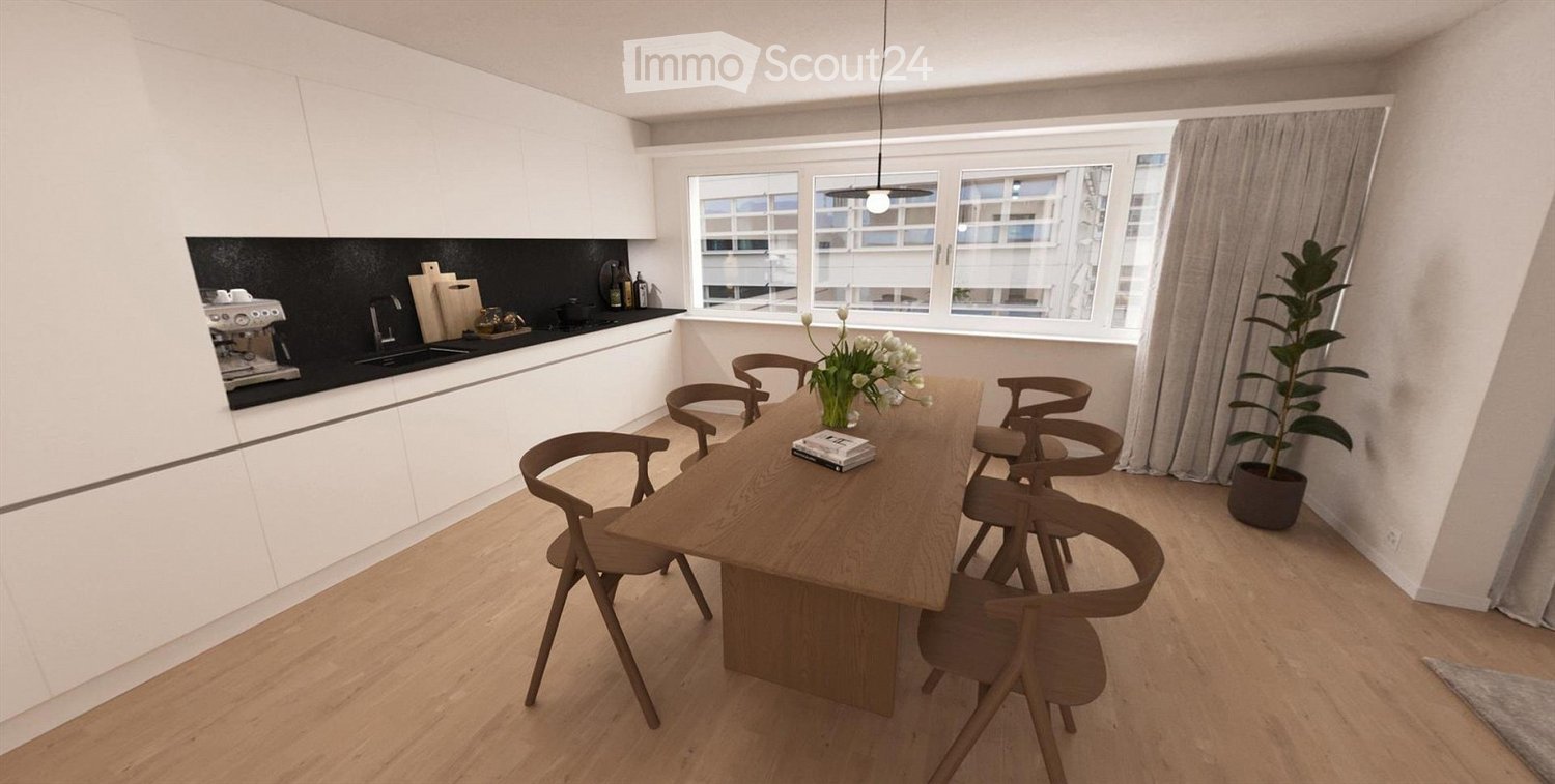 Modern kitchen with white cabinets, wooden table, six chairs, large windows, and a coffee machine on the counter.