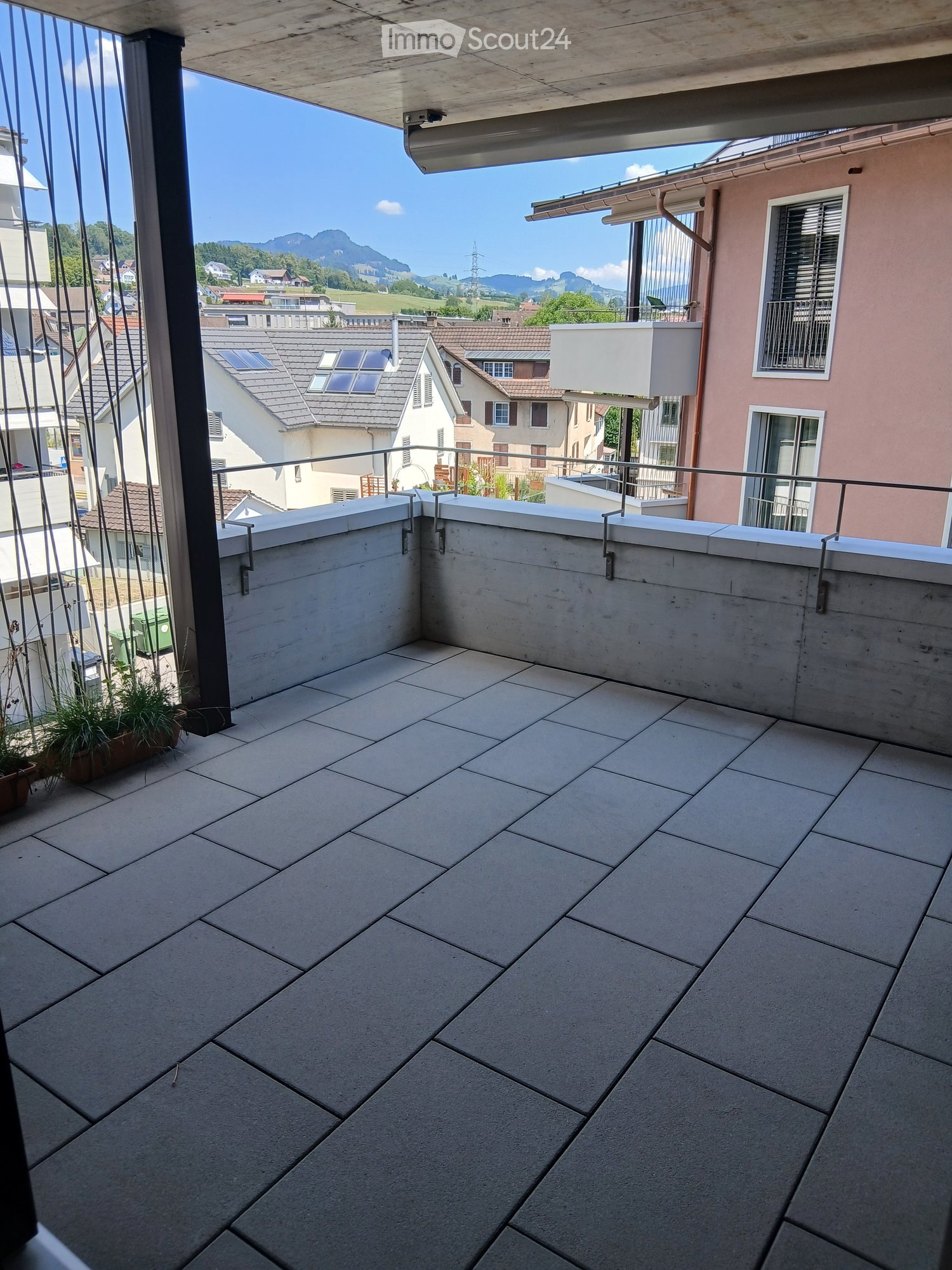 Balcony with tiled floor, metal railing, and scenic mountain view.