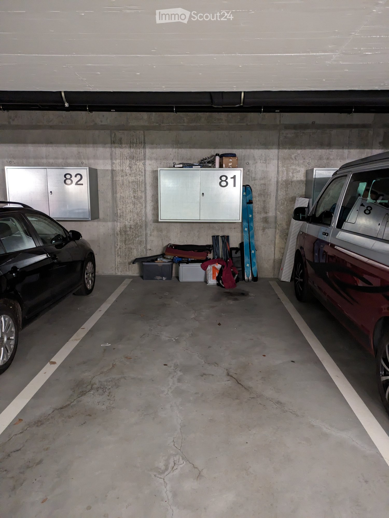 Underground parking area with two cars, a skateboard, and two lockers labeled81 and 82.