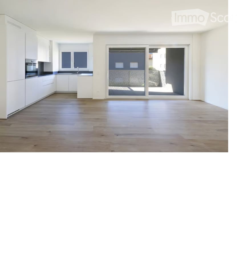 Empty room with wooden flooring, white walls, and large sliding glass doors leading to a balcony.