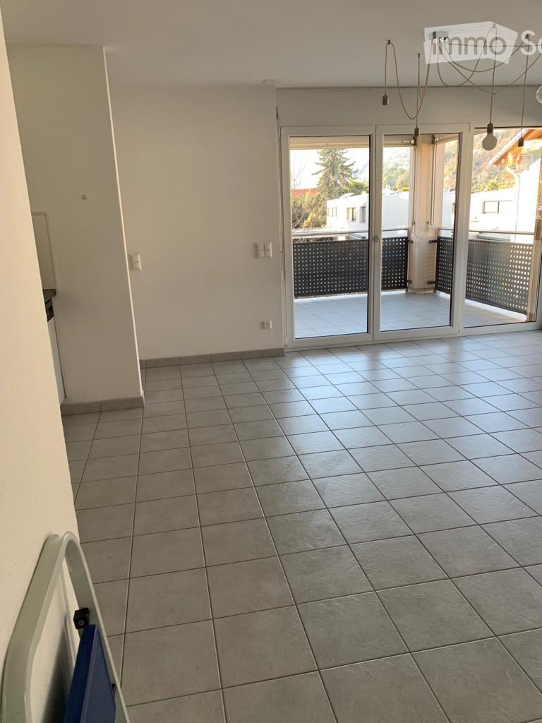 Empty room with tiled floor, white walls, and large sliding glass doors leading to a balcony or terrace area.