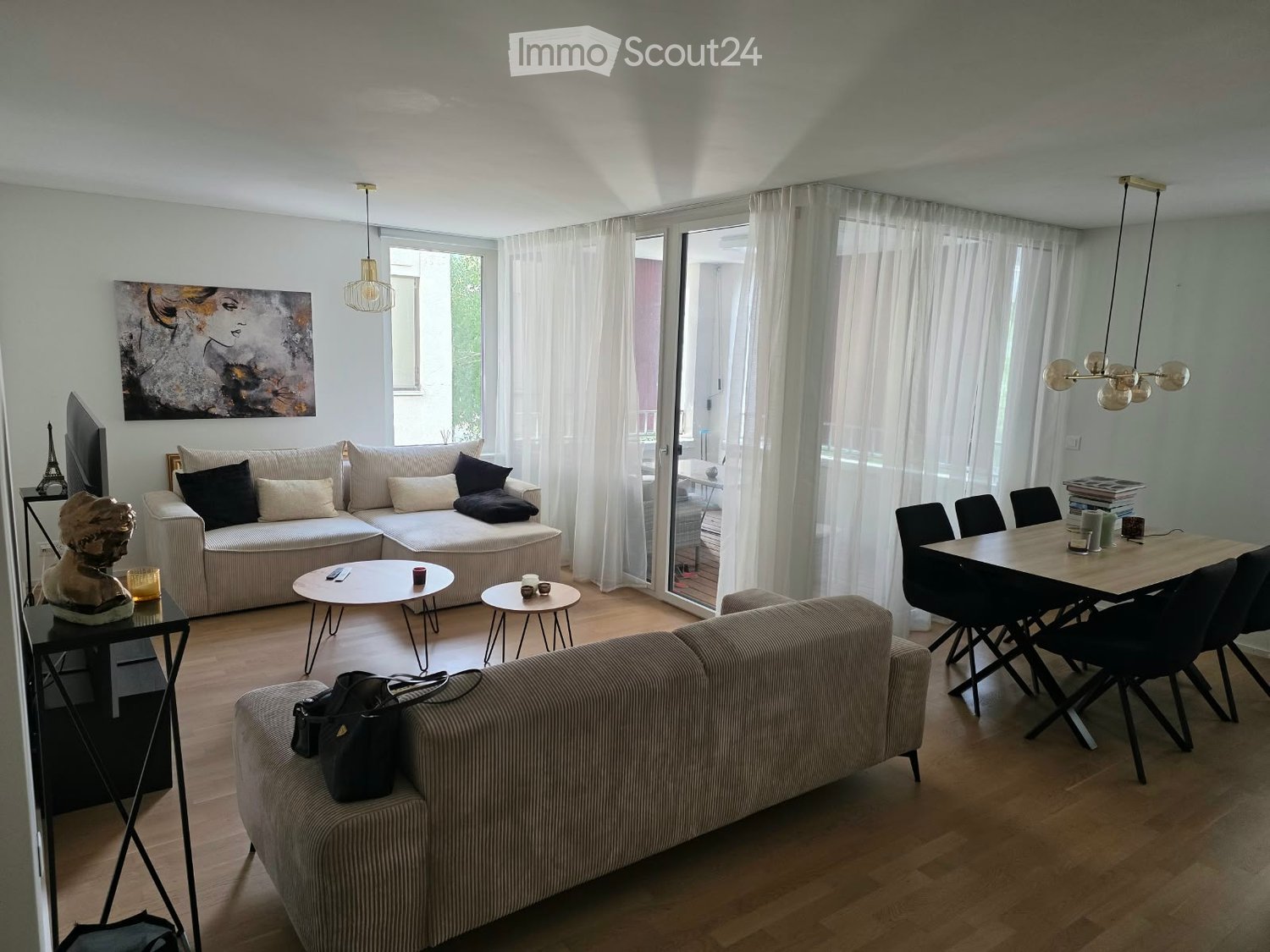 A modern living room with a sectional sofa, coffee tables, dining table, chairs, and decorative items.