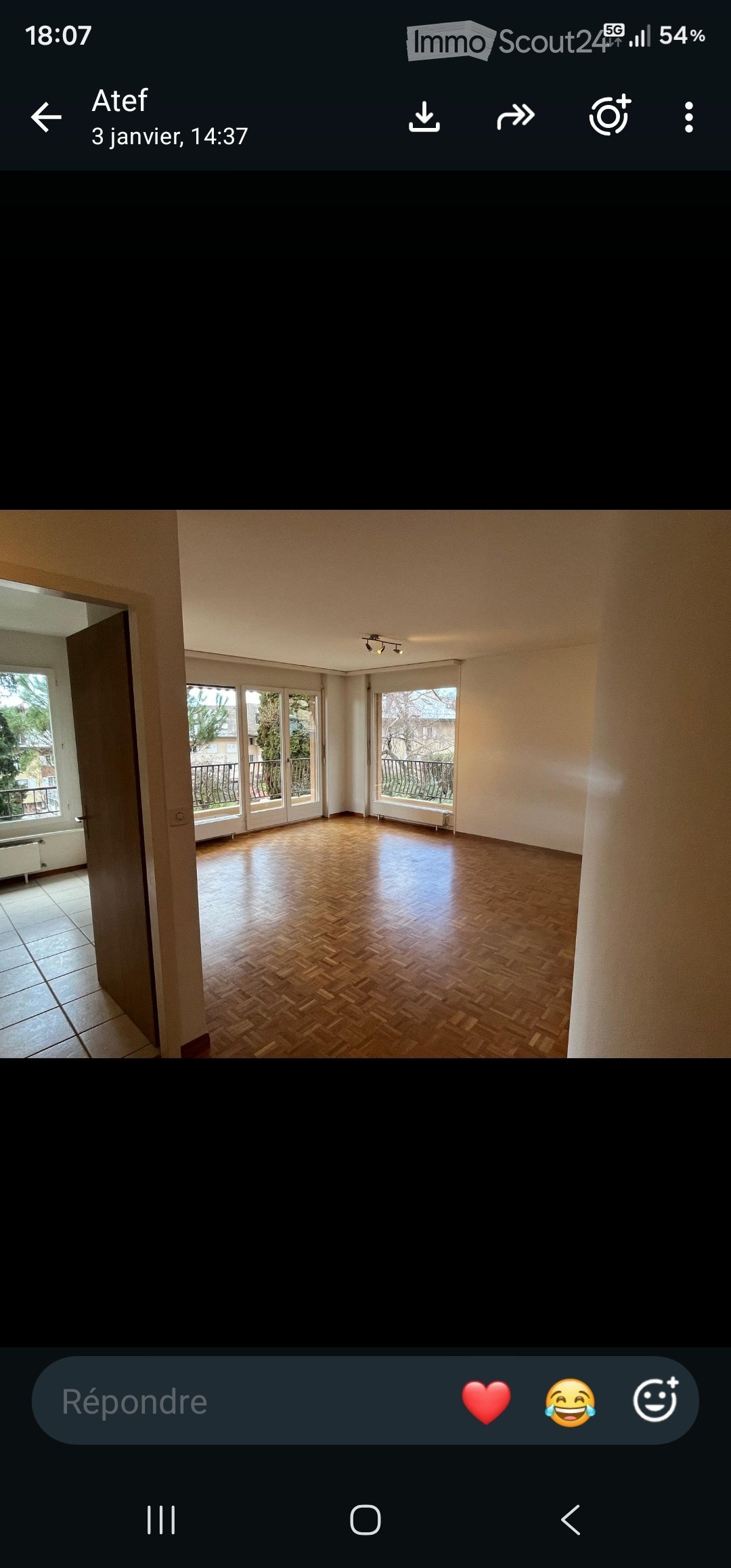Empty room with wooden flooring, large windows, and access to a balcony.