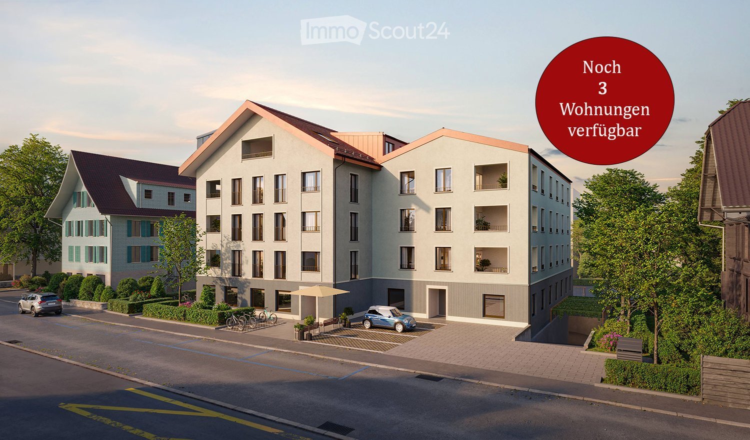 Modern multi-story residential building with balconies, surrounded by greenery and parking area.