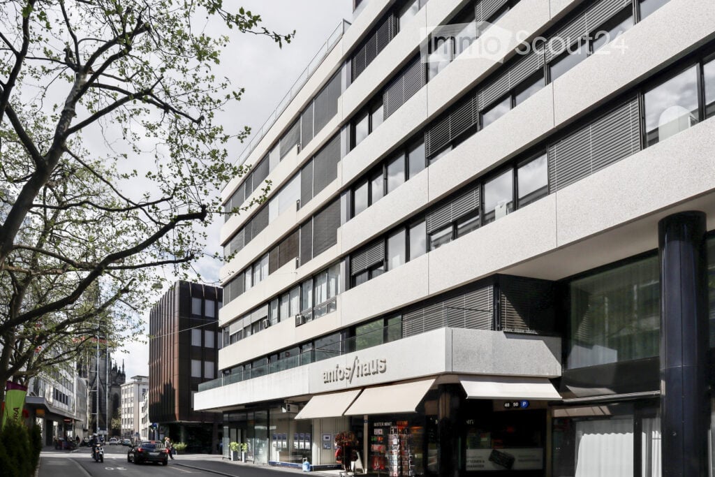 Modern multi-story building with large windows and a sign reading "antifhaus" on the ground floor.