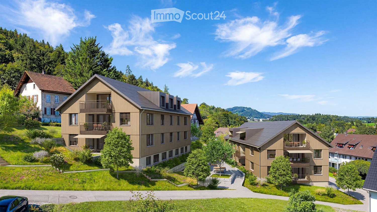 Modern residential complex with multiple townhouses, balconies, and surrounding greenery.