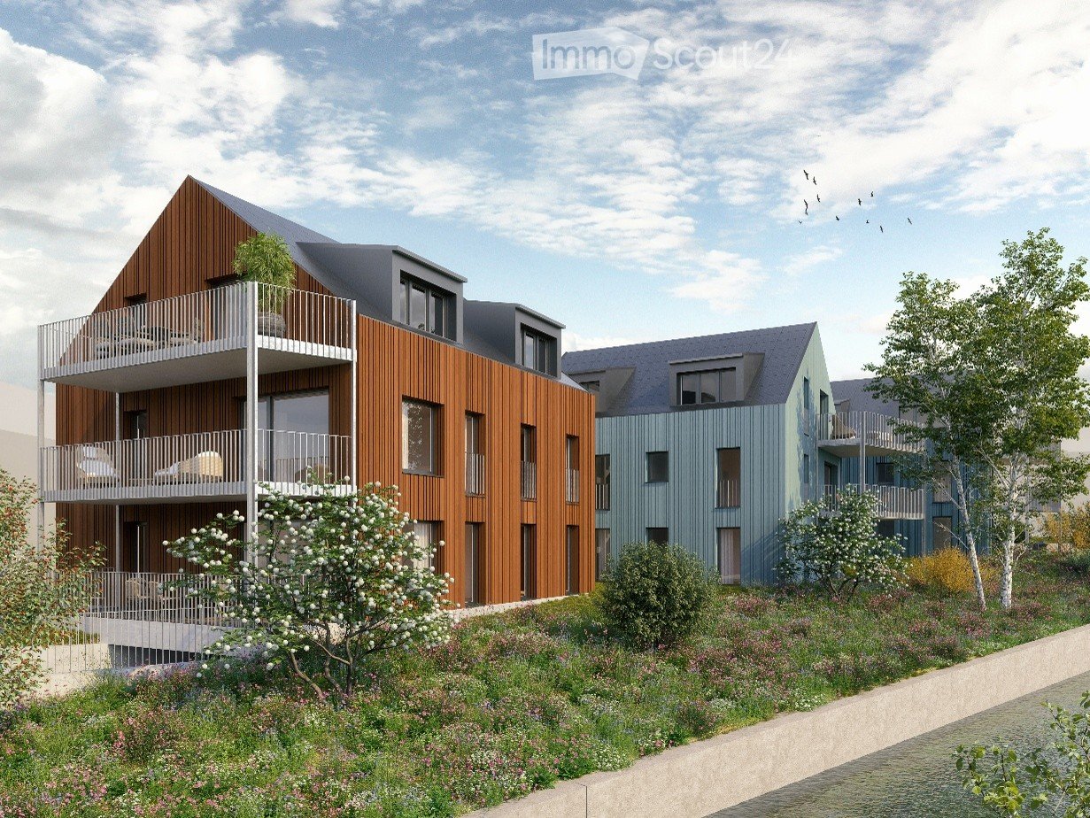 Modern multi-story residential building with wooden and blue facades, balconies, and surrounding greenery.