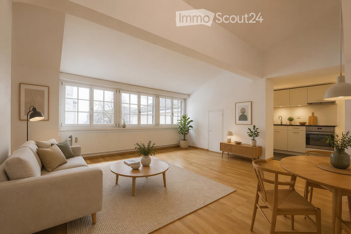 Bright, open living space with wooden flooring, large windows, a sofa, coffee table, dining table with chairs, kitchen area with cabinets and oven, and decorative plants.