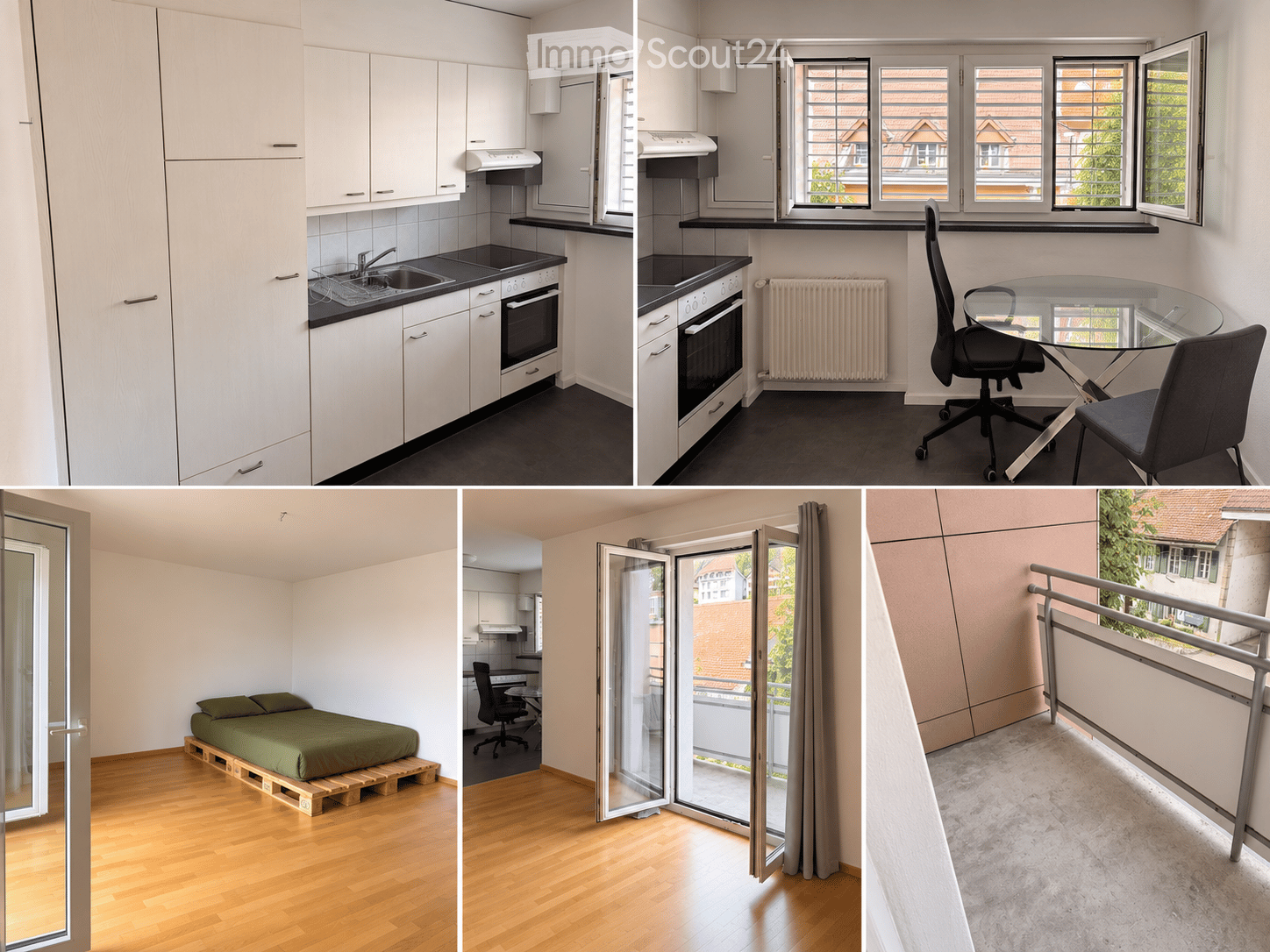 The image shows a modern, compact apartment with a kitchen, a workspace, and a sleeping area. The kitchen features white cabinets, a sink, and an oven. The workspace includes a glass table and chairs. The sleeping area has a simple bed on a wooden platfor