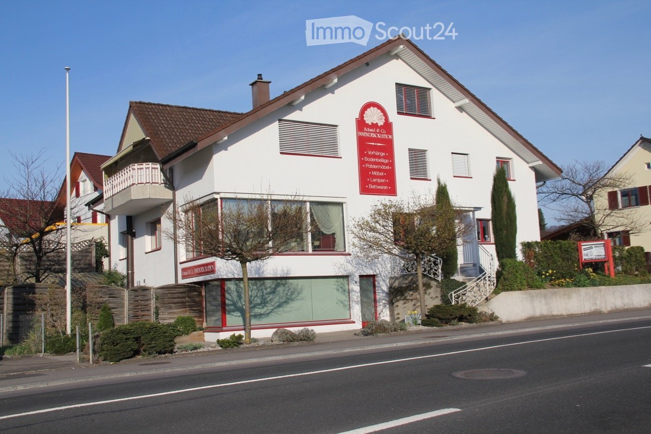 white house, brown roof, balcony, red sign, glass windows, stairs, garden, street