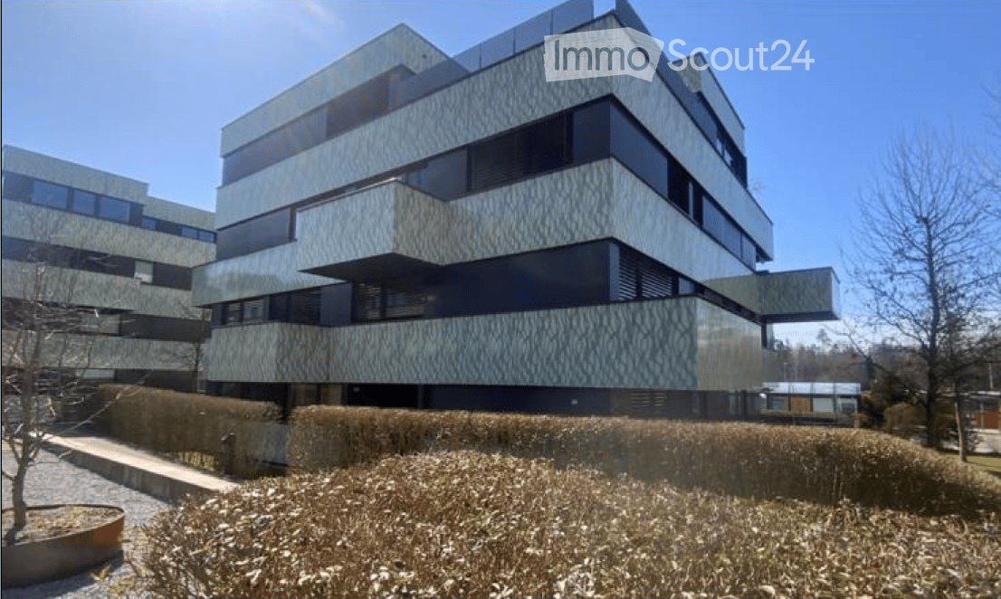 Modern multi-story building with a sleek, contemporary design featuring large windows and geometric patterns on the facade.
