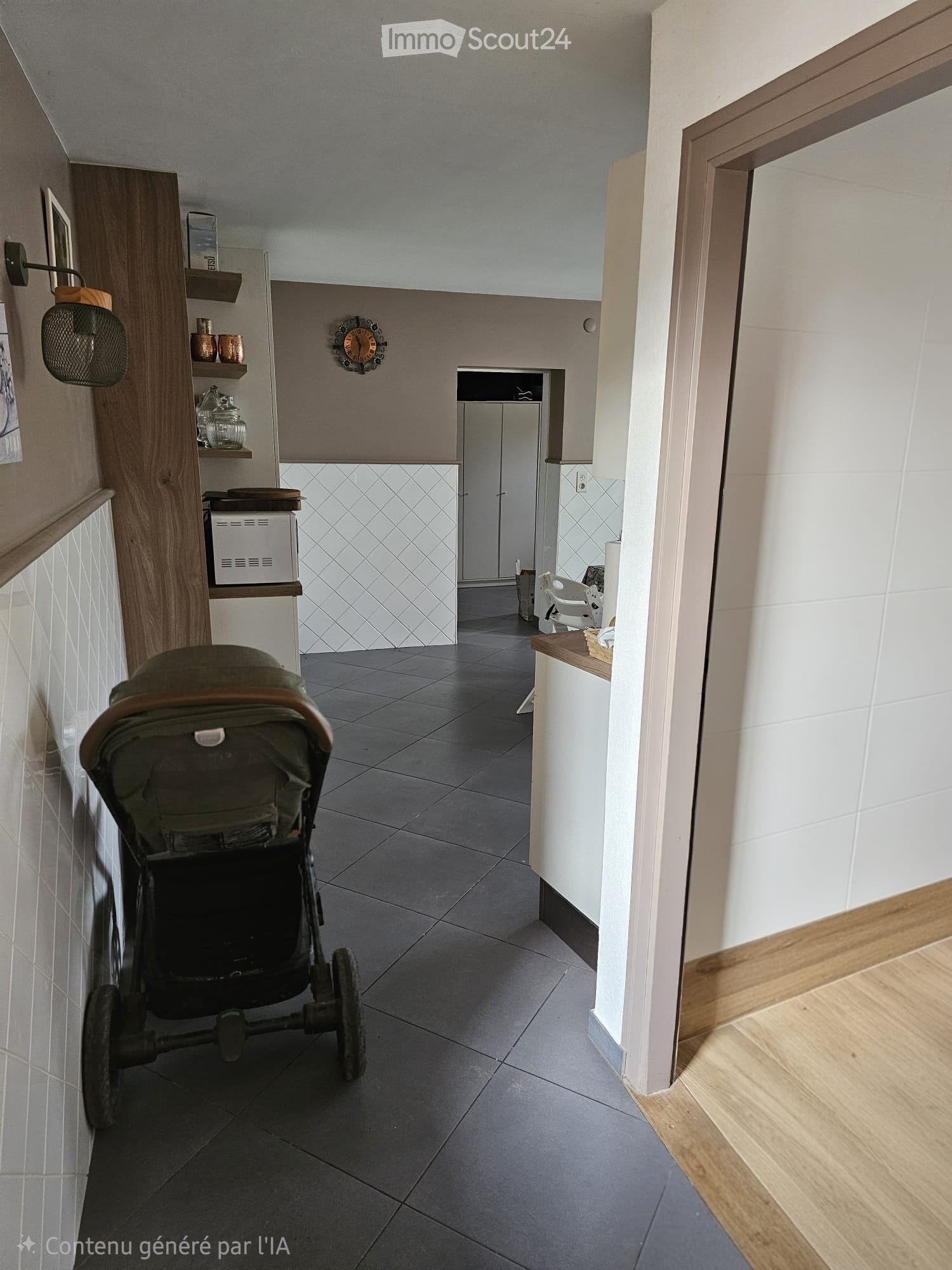 Modern hallway with grey tiled floor, white walls, wooden trim, and a stroller in the foreground. Shelves with decorative items and a small room visible at the end.
