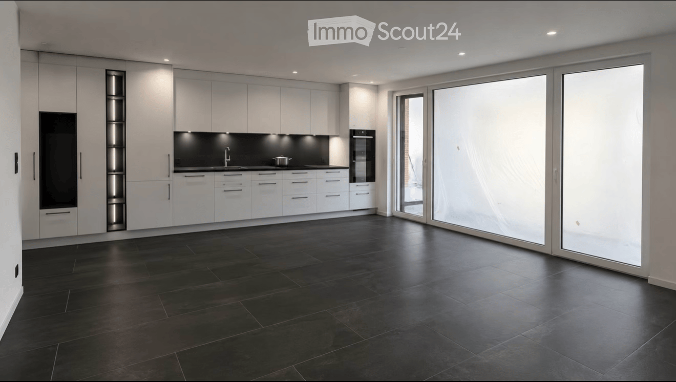Modern kitchen with white cabinets, black countertops, and large glass sliding doors leading to an outdoor area.