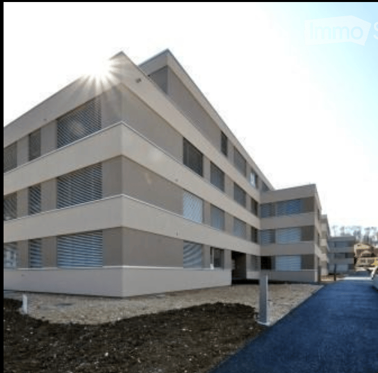 Modern multi-story building with a clean, contemporary design, featuring large windows and a symmetrical facade.