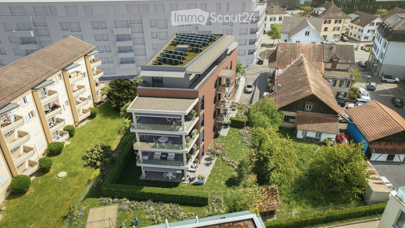 Aerial view of a residential area with multiple apartment buildings, balconies, and surrounding greenery.