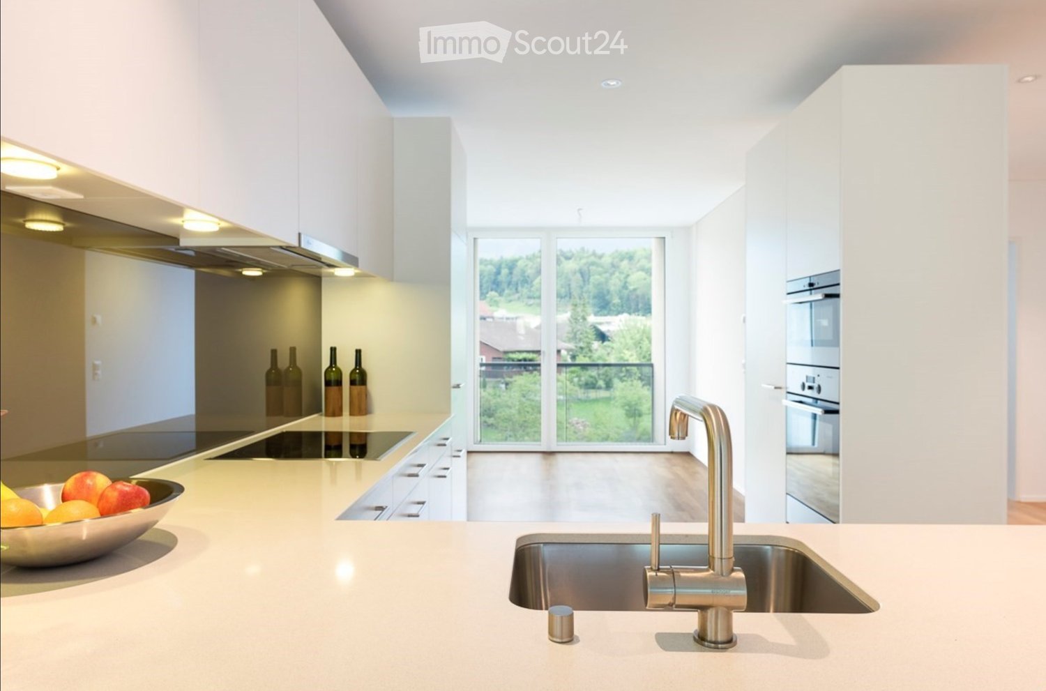 Modern kitchen with white cabinets, stainless steel appliances, a large island, and a view of the outdoors.
