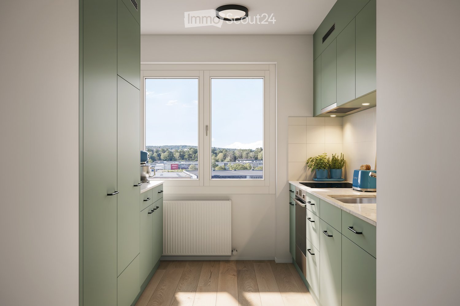 Modern kitchen with light green cabinets, wooden flooring, and large windows offering a view of greenery outside. Features include a sink, oven, toaster, and small potted plants on the counter.