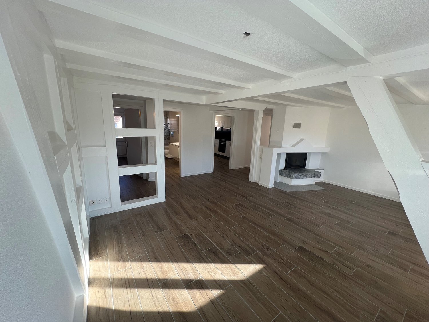 Fireplace, wooden floor, white walls, 4 doors