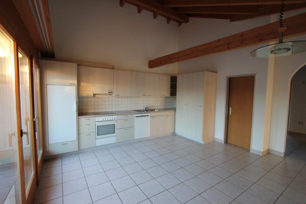 kitchen with modern appliances, white cabinetry, tiled floor, windows, ceiling beams