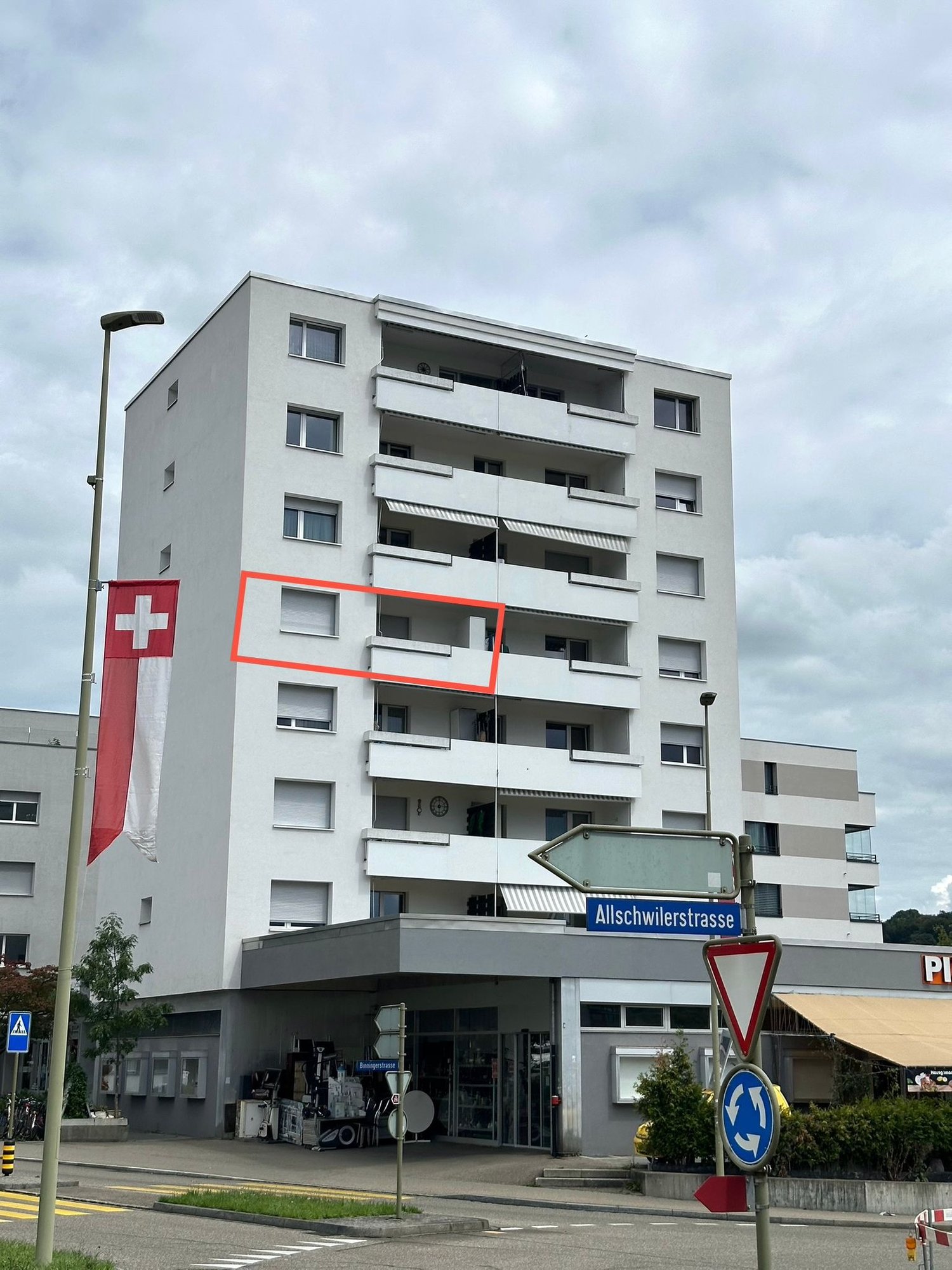 multi-story residential building, multiple balconies, modern design, red outline indicating highlighted unit