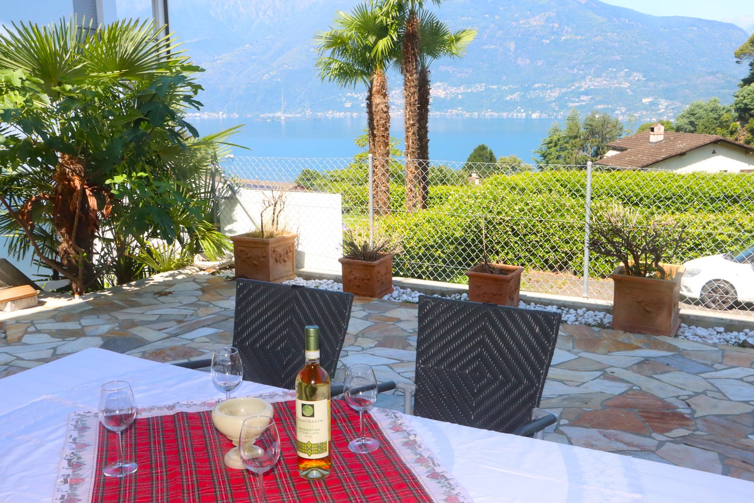 Stone floor, garden table, chairs, scenic view of mountains and lake