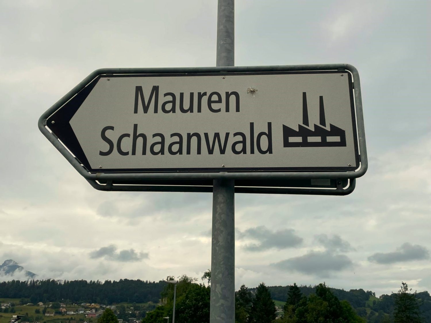 Street sign pointing to the direction of 'Mauren Schaanwald', located outdoors