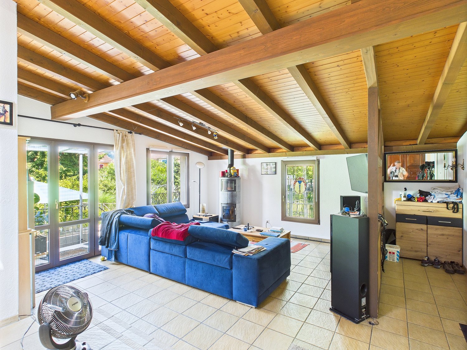 large wooden beams, blue sofa, coffee table, television, cabinet, speaker