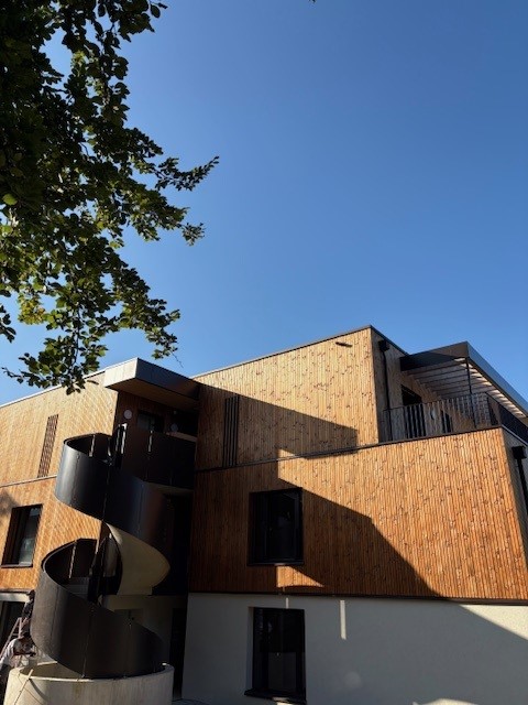 wood facade, 3 stories, black spiral staircase, balcony