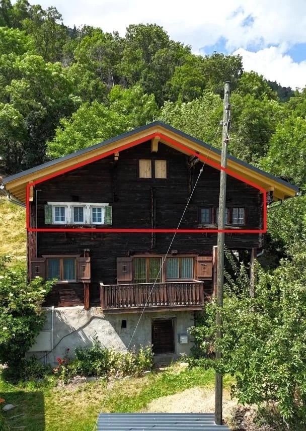 two story house, wooden exterior, slanted roof, wooden balcony, surrounded by plants