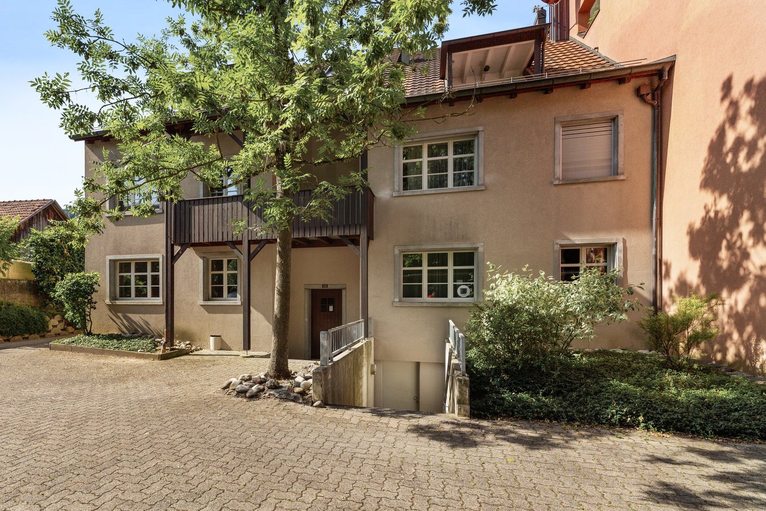 Two story house, balcony on the second floor, gravel driveway