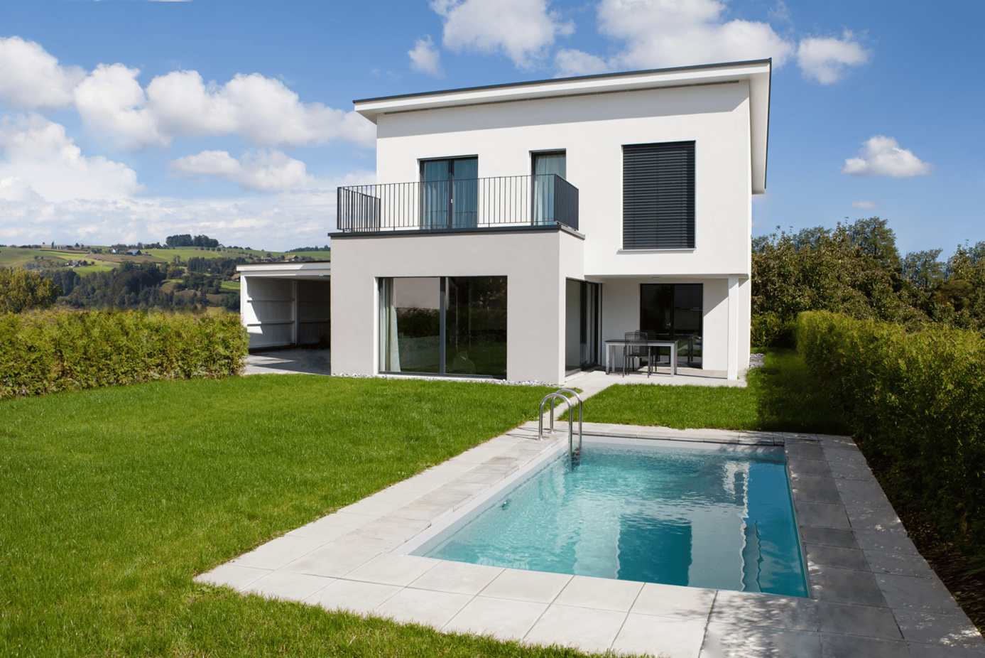 Modern 2 story white house, tiled roof, balcony, glass wall, swimming pool, grassy garden
