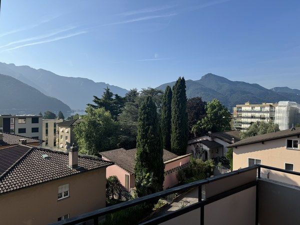 Balcony overlooking cityscape with mountains in the background