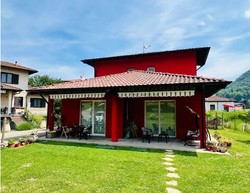 Red house, terrace, garden, patio, green grass, mountain in background