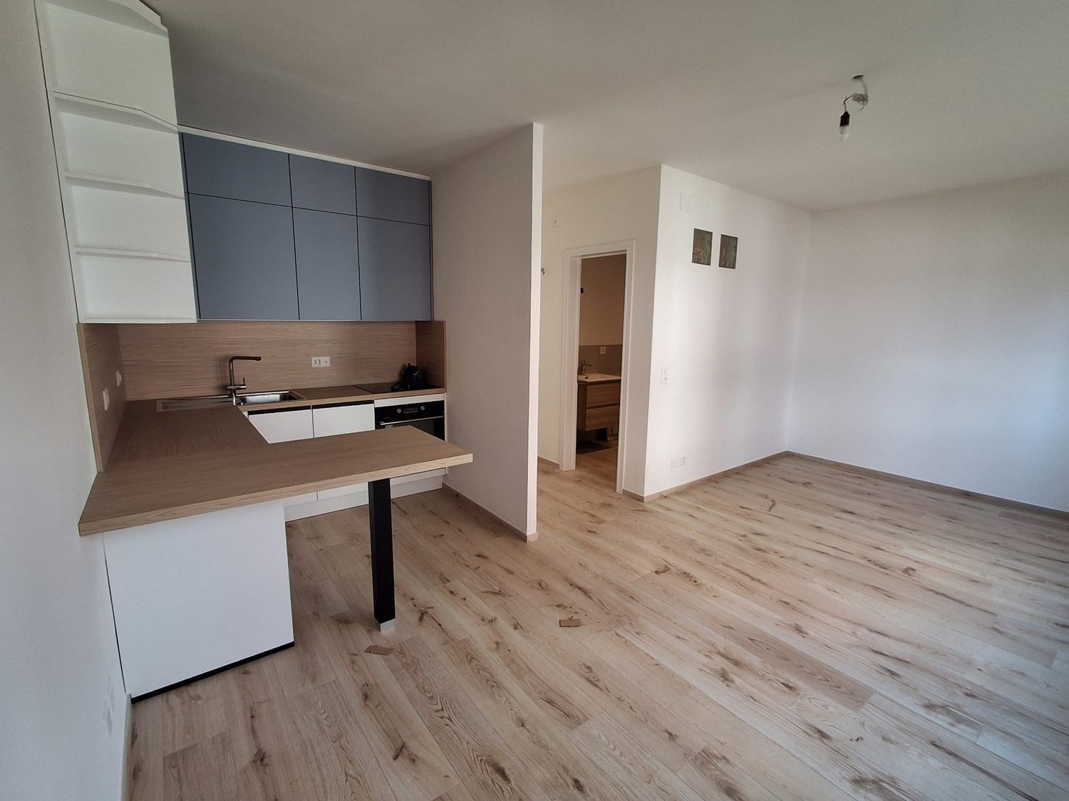 modern kitchen, equipped with stainless steel appliances, wooden countertops, white cabinets, hardwood floors, open to the living area