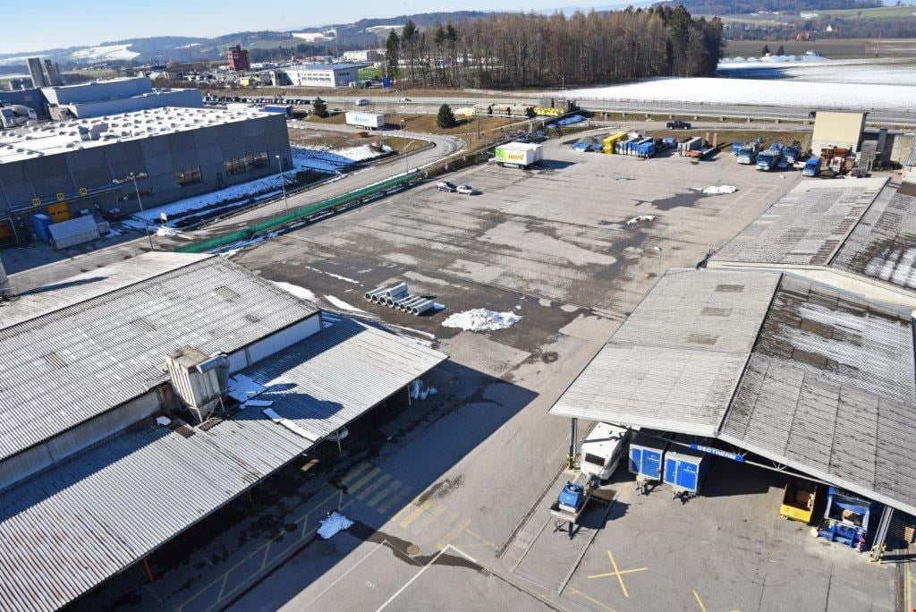 Large industrial complex with warehouses, storage facilities, and parking areas. The area appears to be used for commercial and logistical purposes.
