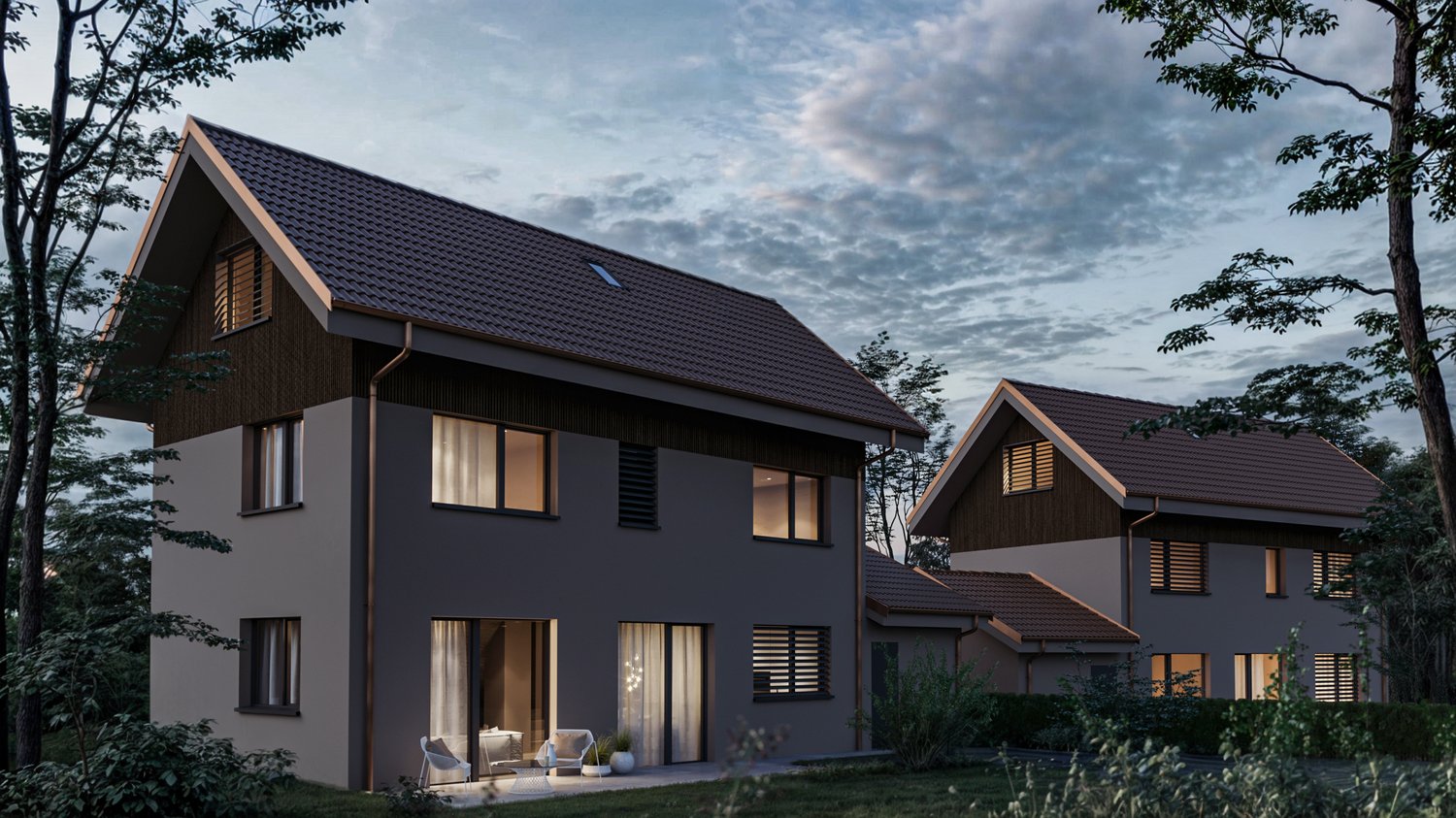 Two-story modern house with dark wooden siding, large windows, and a slanted roof. The house is surrounded by trees and has a balcony or terrace visible.