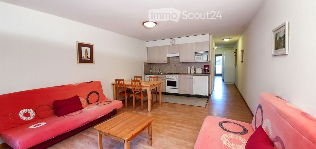 wood floor, two couches, wooden table, dining area, kitchen, oven, microwave