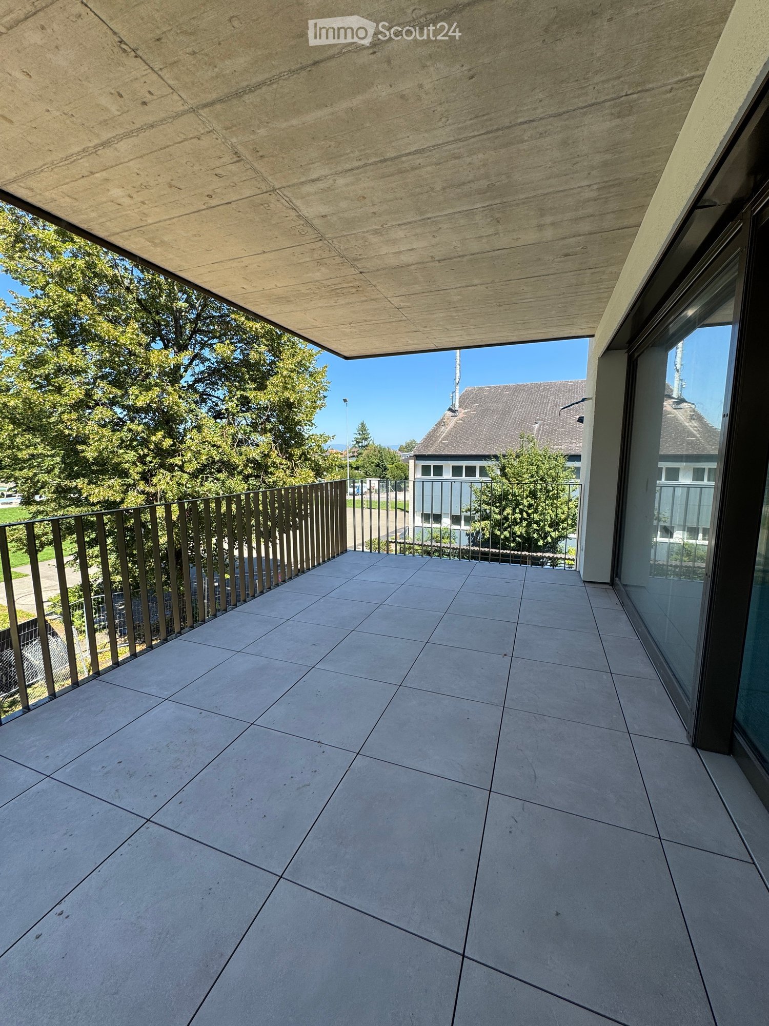 Slate floor, metal railing, view of trees and distant buildings